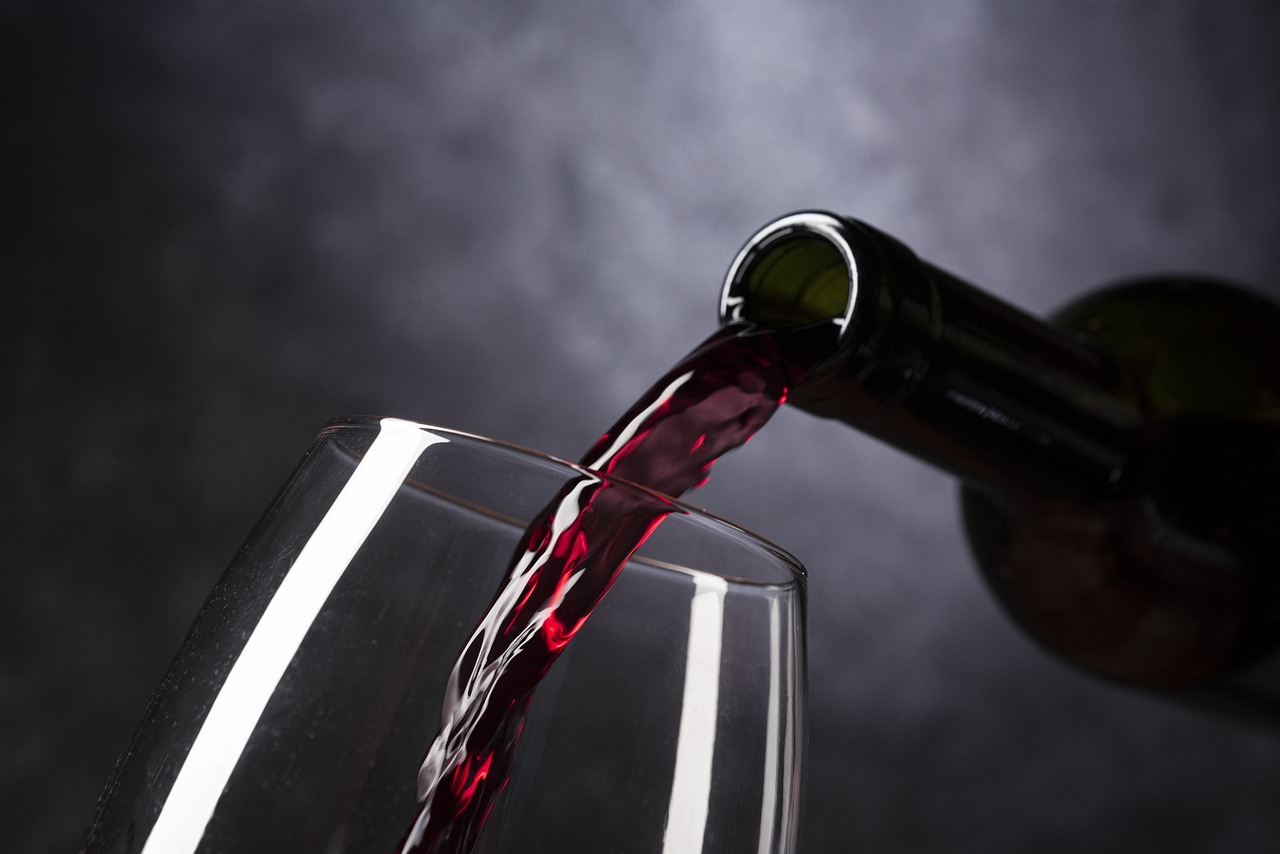 Bouteille servant du vin rouge dans un verre